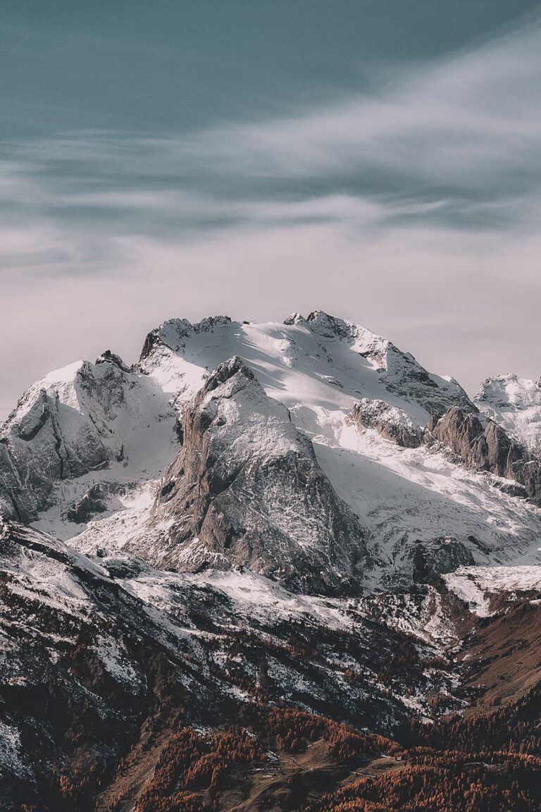 A breathtaking view of a snow-capped mountain range under a clear sky, capturing winter's beauty.