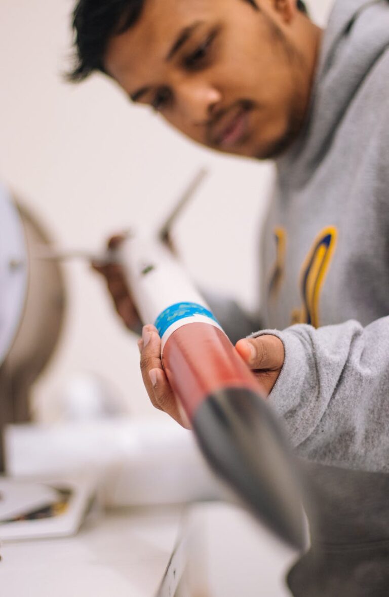 Focused student inspecting a model rocket, emphasizing STEM learning and precision engineering.