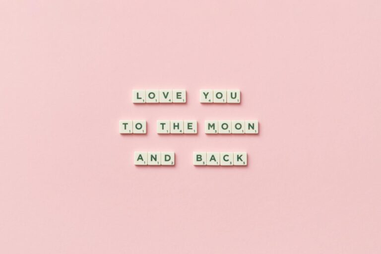 Letter tiles spelling 'Love You to the Moon and Back' on a pink background.