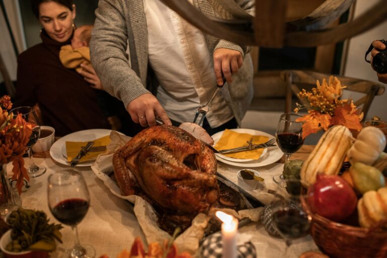 A festive Thanksgiving family gathering with carving a roasted turkey and holiday decor.