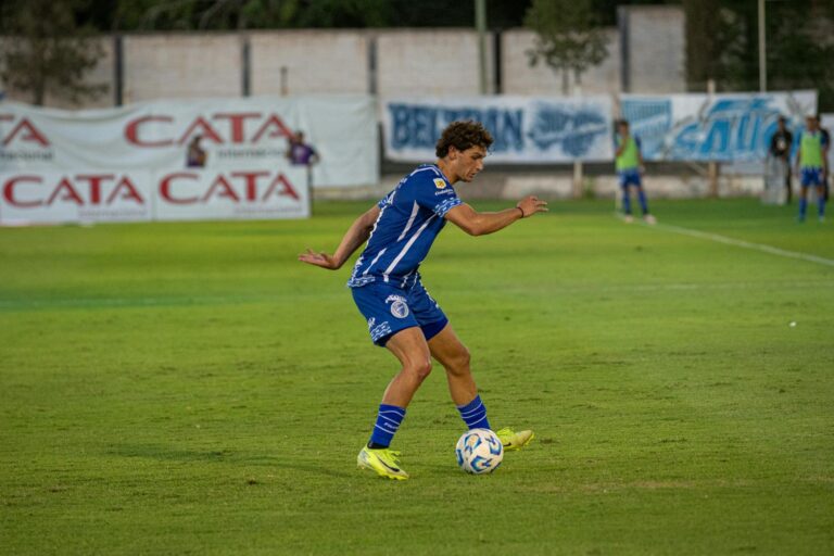 Young male soccer player in action on a grass field. Energetic and focused.