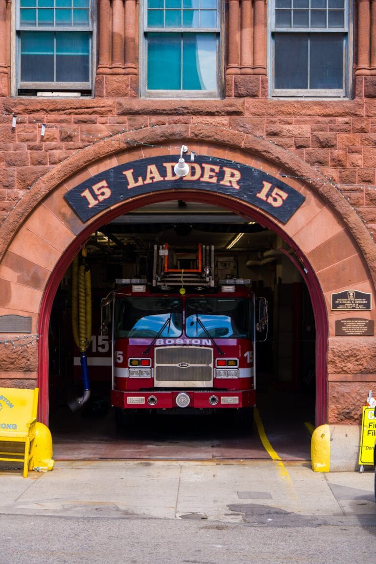 Red firetruck in classic Boston fire station archway, capturing urban architecture.