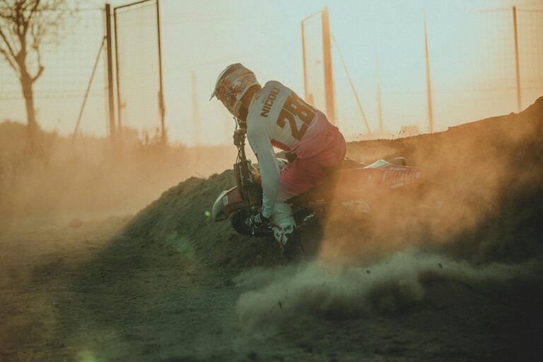 Motocross rider racing through dirt track during a golden sunset in Los Angeles.