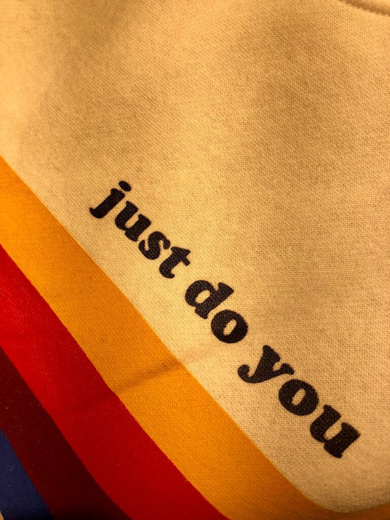 Close-up of vibrant fabric with motivational text 'just do you' on colorful stripes.