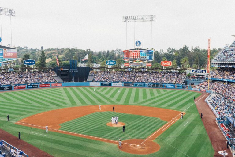 Vibrant baseball game at Dodger Stadium with packed stands and players on the field.