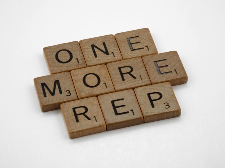 Scrabble tiles arranged to spell 'One More Rep', symbolizing fitness motivation.