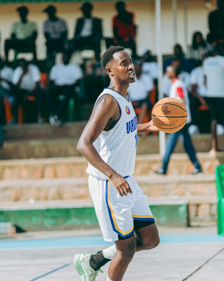 A young male basketball player dribbling on an outdoor court during a game.