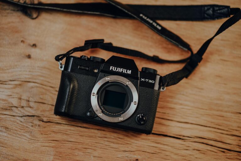 Close-up of a Fujifilm X-T30 camera body resting on a wooden surface, ideal for photography enthusiasts.