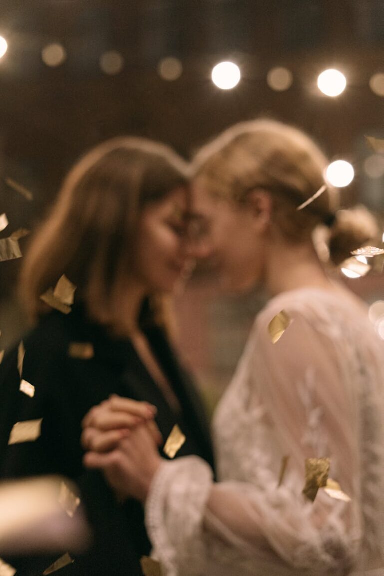 A romantic dance between two women, surrounded by golden confetti at a party event.