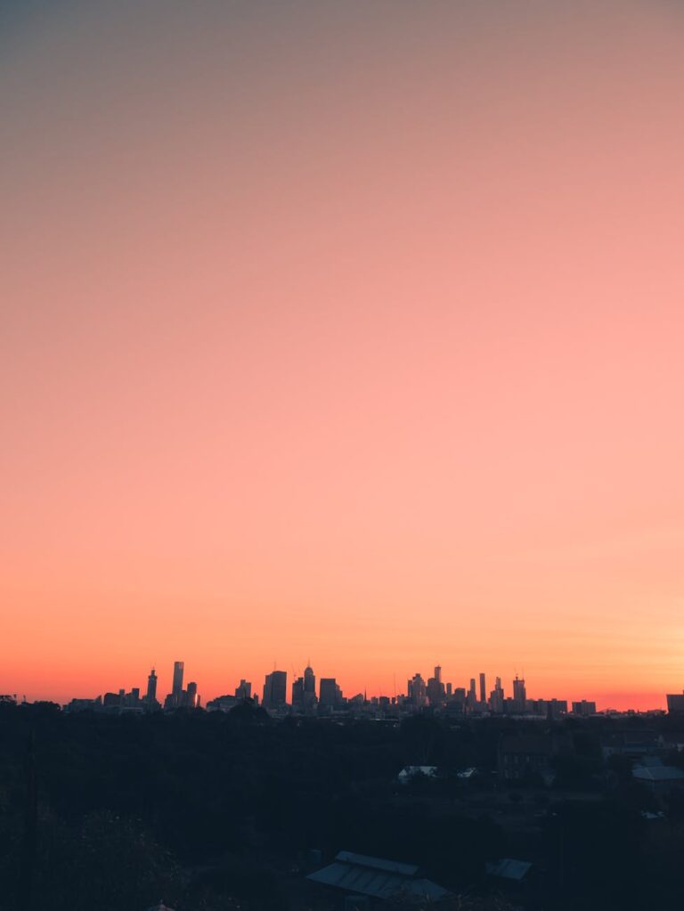 Stunning silhouette of Melbourne's skyline at sunset, showcasing vibrant skies over urban architecture.
