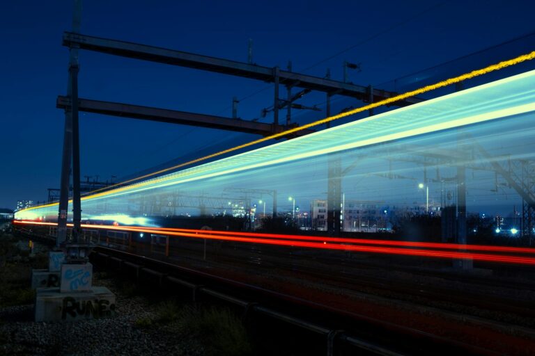 Long exposure of a train at night in London, capturing vivid light trails.