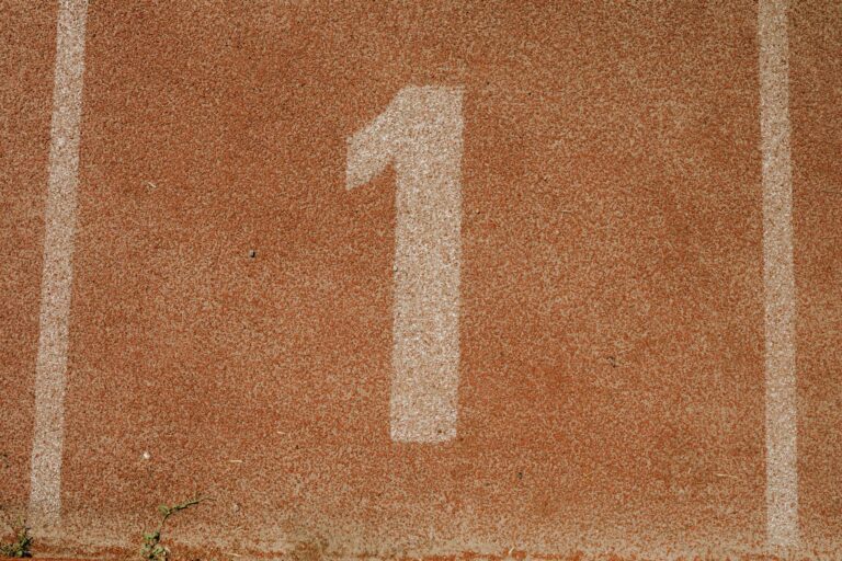 Close-up image of number one lane on a running track, symbolizing first place.