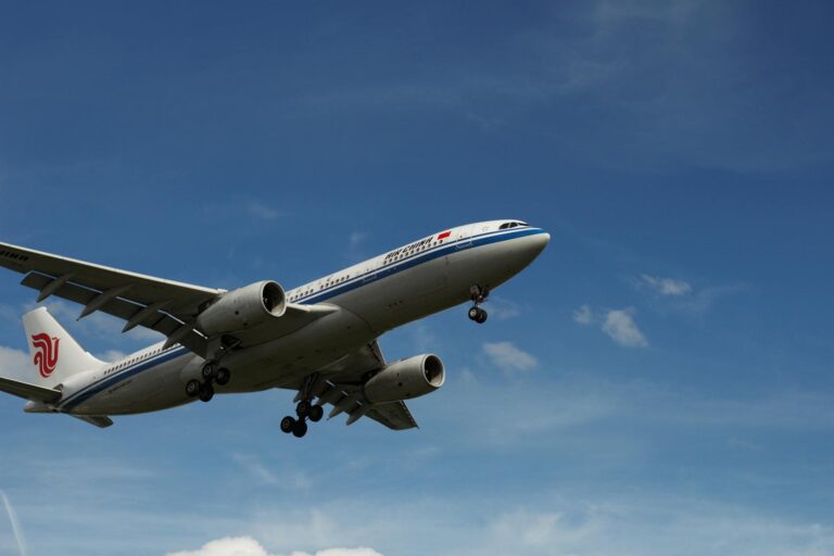 A commercial airplane in flight against a clear blue sky, showcasing modern air travel.