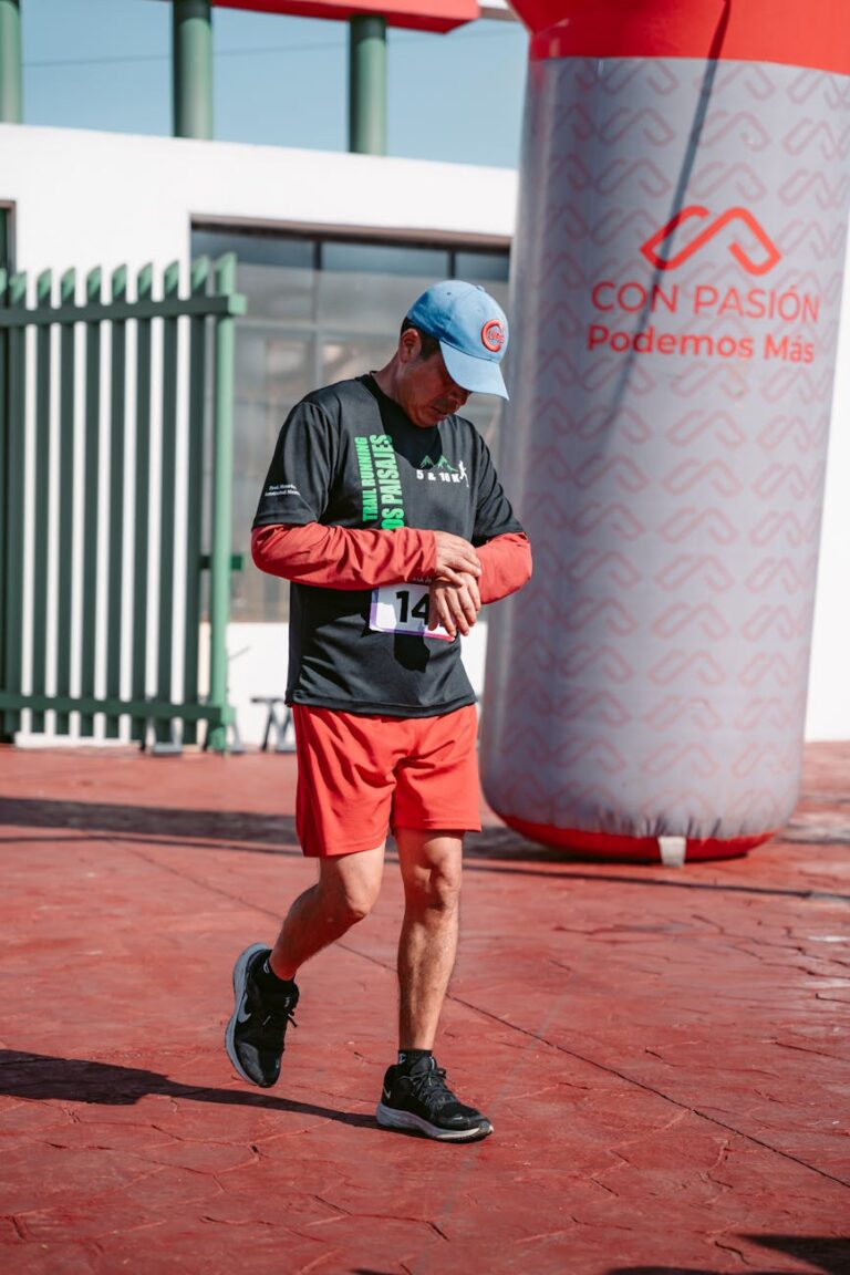 Adult male runner checking his watch during an outdoor sports event.