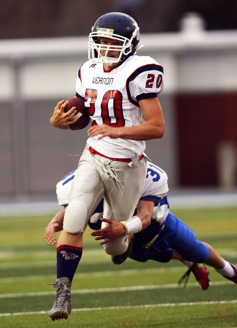 Dynamic shot of high school football players during a game, showcasing a quarterback in action.