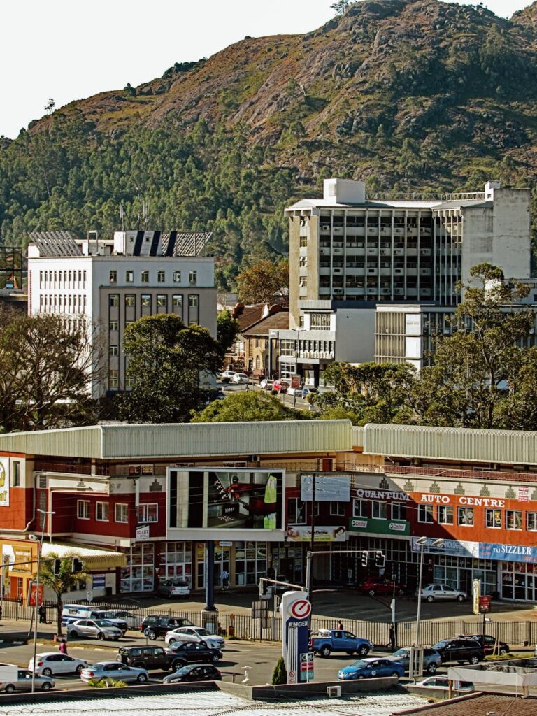 Explore the bustling streets and architecture of Manzini with a backdrop of lush hills.