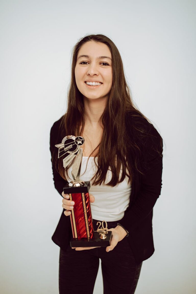 Joyful woman celebrating with a trophy, symbolizing achievement and success.
