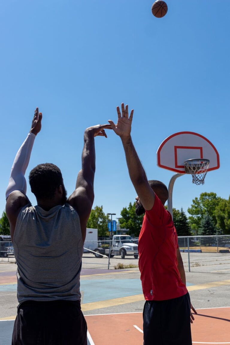 Two men playing a competitive game of basketball on an outdoor court.
