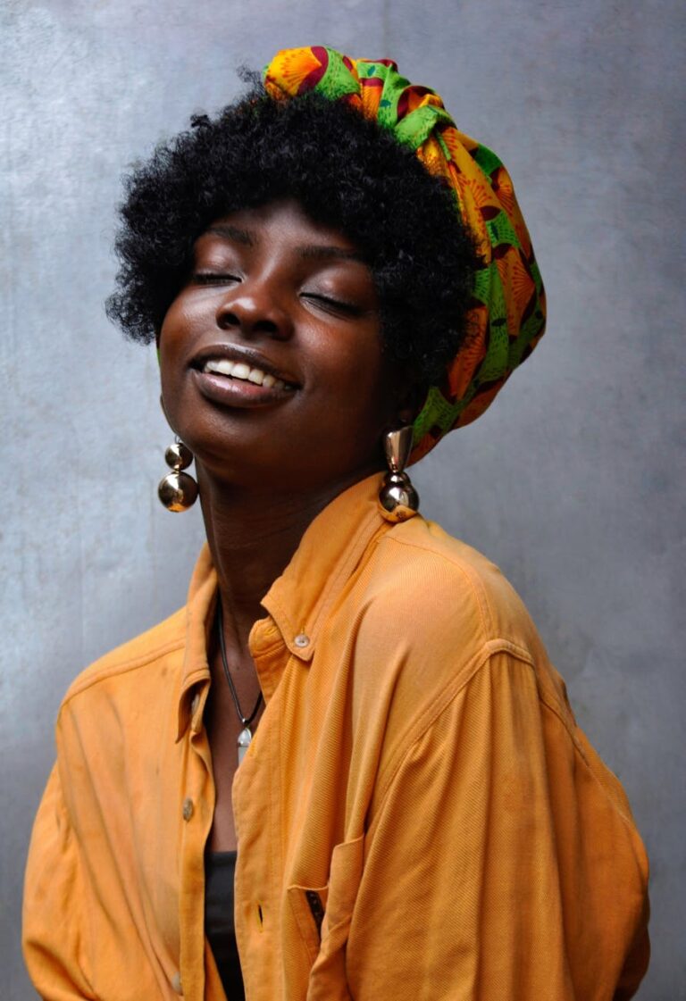 Captivating portrait of an African woman wearing a headscarf and bold earrings, exuding confidence.