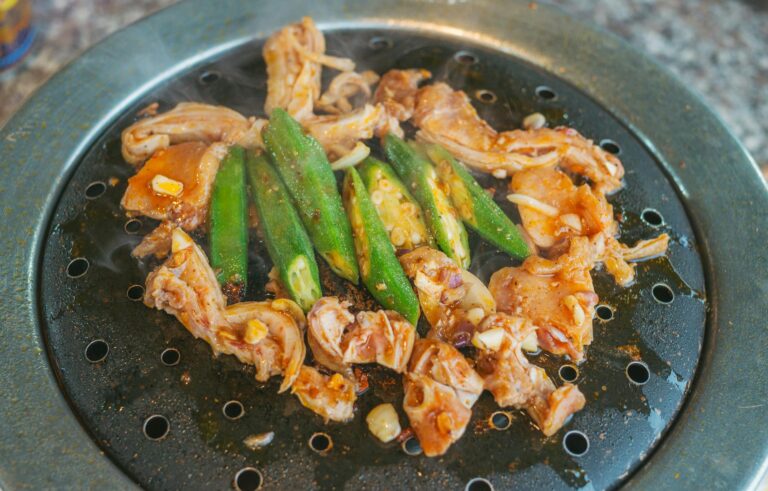 Appetizing grilled chicken and okra sizzling on a Korean barbecue grill, ready to serve.