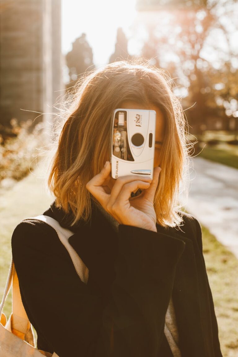 A woman captures moments on a sunny day with a vintage camera outdoors.