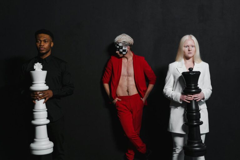 Creative portrait featuring diverse models with large chess pieces, blending fashion and strategy.