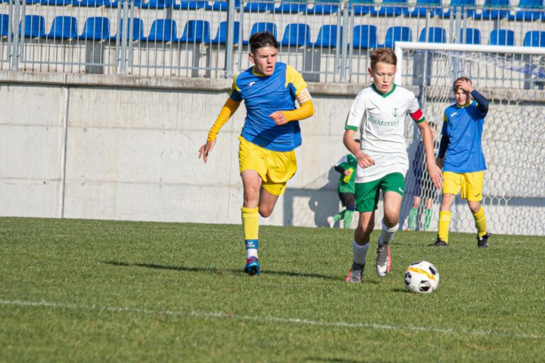 Young soccer players competing in a match on a sunny day in Slovakia.