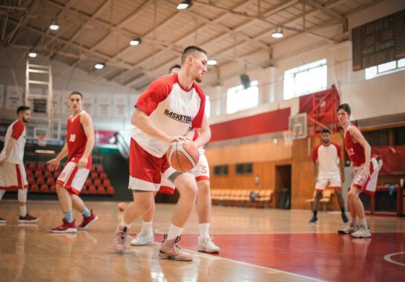 Male basketball players practicing on an indoor court, focusing on teamwork and athletic performance.