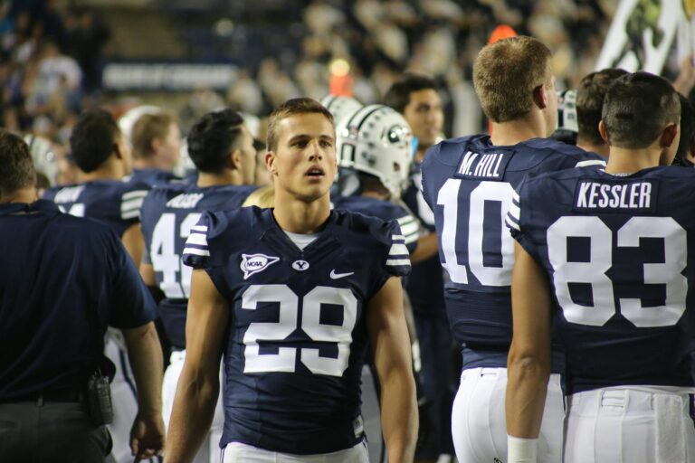 A team of American football players standing on the sidelines during a game.
