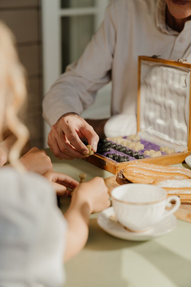 A touching moment of a family playing chess while sharing a cup of tea.