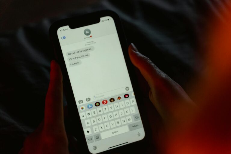 Close-up of a breakup message on a smartphone screen, held in hands, evoking emotions.