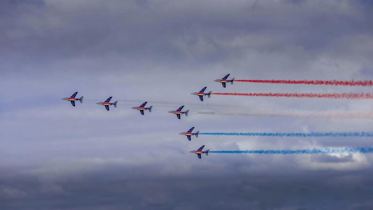 Stunning aerial display by French airforce jets with red, white, and blue trails.