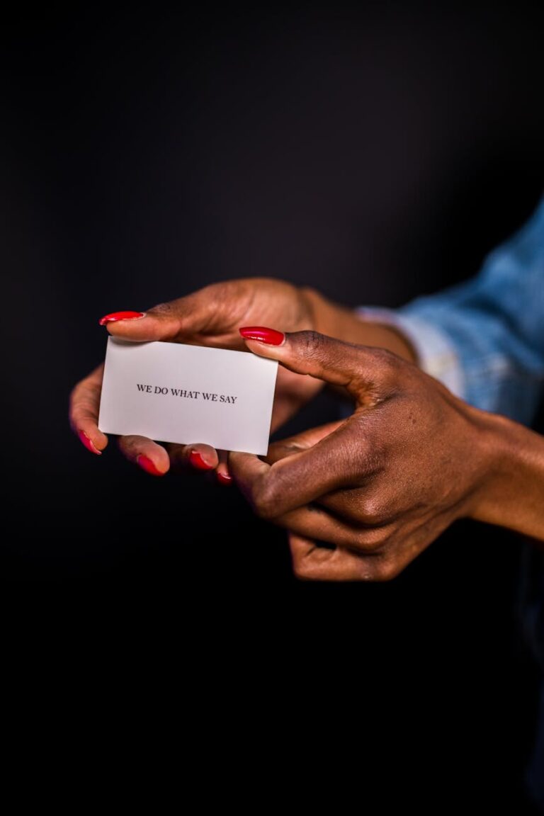 Close-up of a woman's hands holding a motivational card with 'we do what we say'.