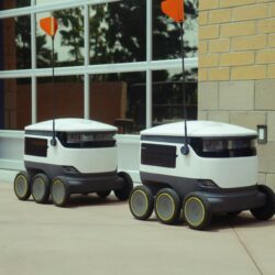 Futuristic autonomous robots designed for efficient outdoor food delivery.