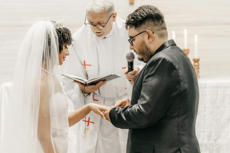 Bride and groom exchanging vows in a church ceremony led by a priest.