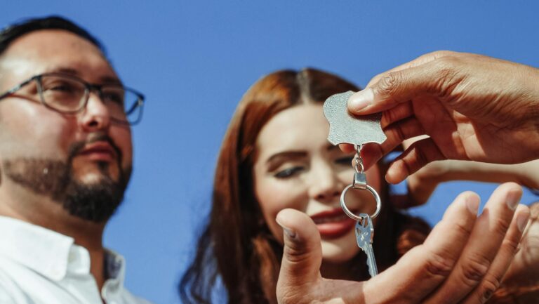 A couple receiving keys to a new home, symbolizing property ownership or real estate purchase.