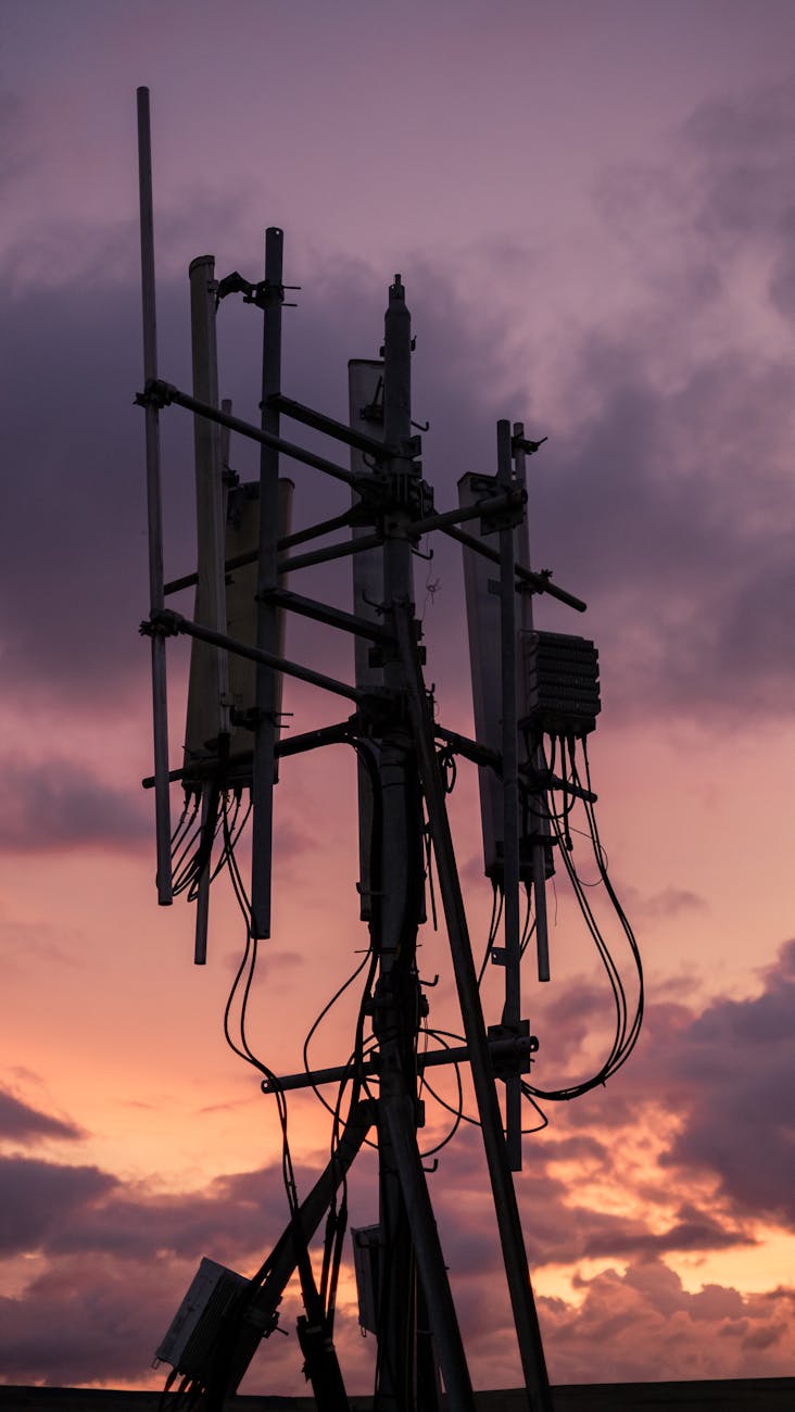 Silhouette of a communication tower against a vibrant sunset sky.
