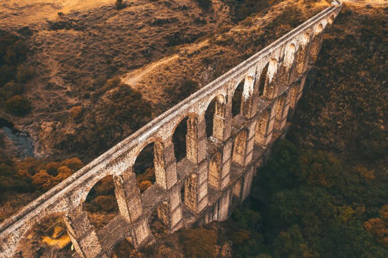 Breathtaking aerial shot capturing a historic Roman aqueduct amidst scenic landscape during sunset.