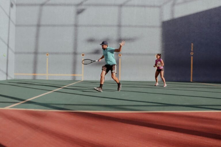 Dynamic tennis match on an outdoor court with a man and woman in action.