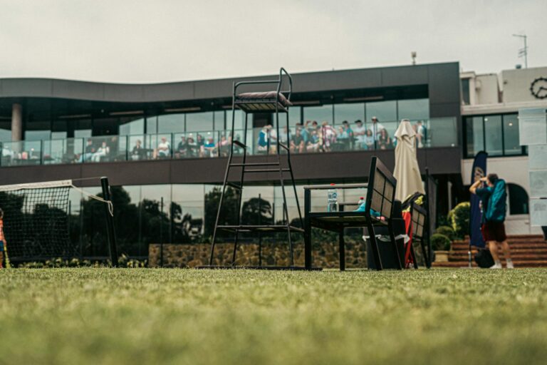 A vibrant tennis court scene with spectators in a modern facility in Melbourne, Australia.