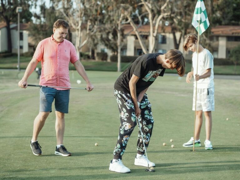 Group of three friends enjoying a casual golf game on a sunny day.