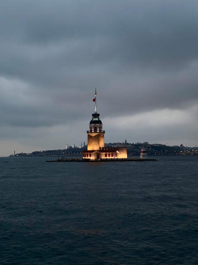 Dramatic view of Maiden's Tower lit up at dusk in Istanbul, Türkiye.