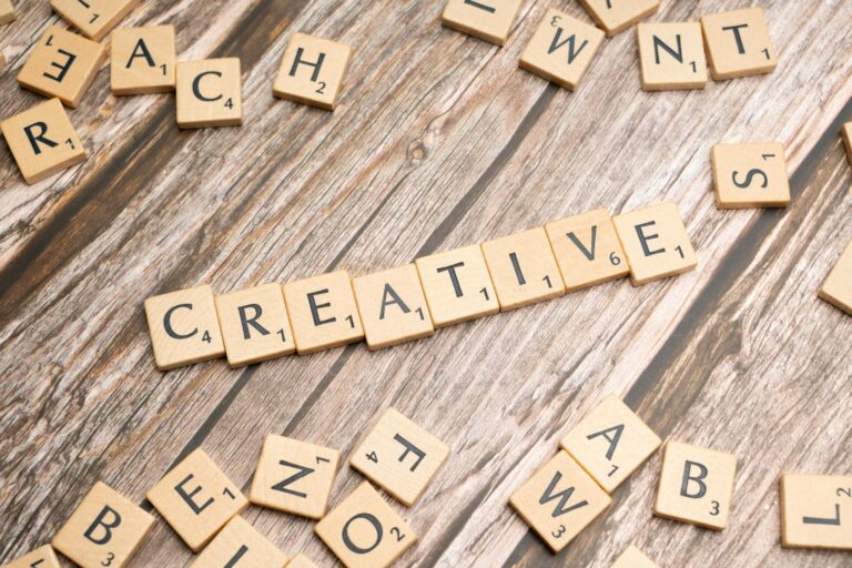 Wooden tiles on a rustic background spelling the word 'creative'.
