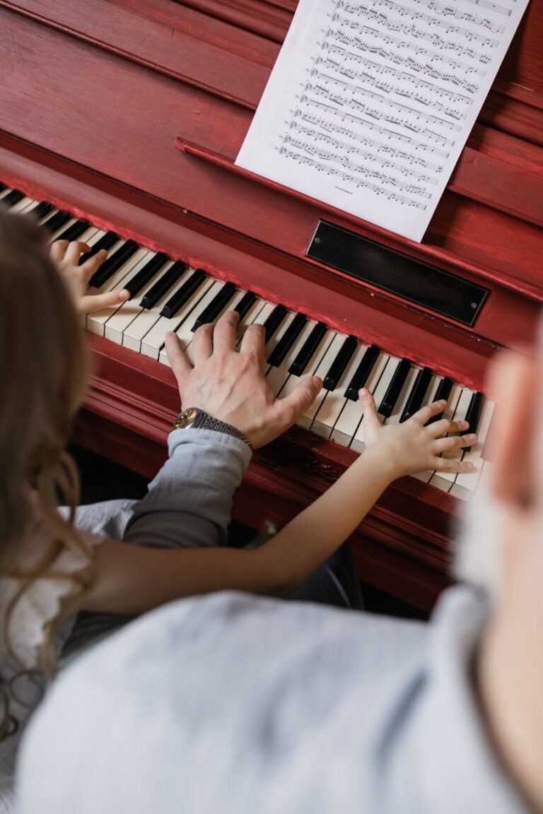 A grandfather and granddaughter bond while playing the piano, highlighting family togetherness.