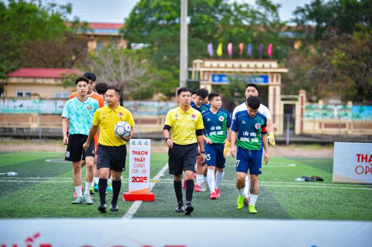 Football teams entering the field for Thạch Thất Open Cup 2025 in Hà Nội, Vietnam.