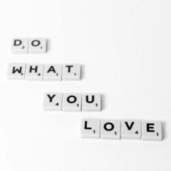 Scrabble tiles spelling 'Do What You Love' on a minimalist white background.