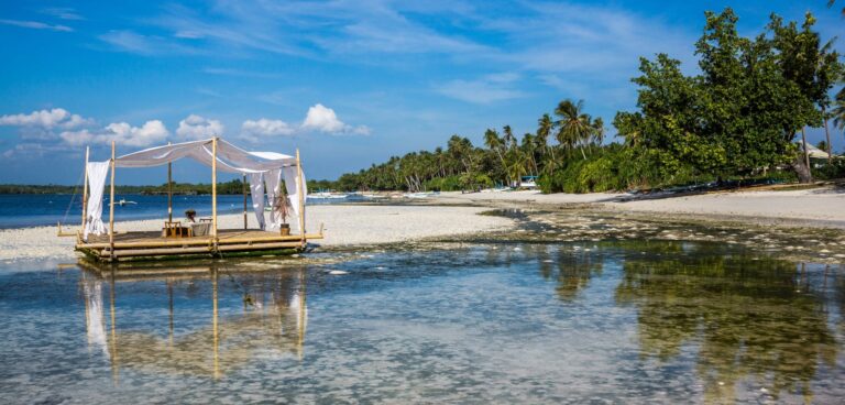 A picturesque tropical island with a cabana on a serene beach, perfect for relaxation.