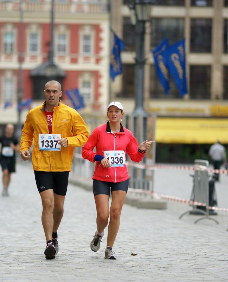 Male and female runners participating in a marathon event through Wrocław city streets, showcasing athleticism and competition.