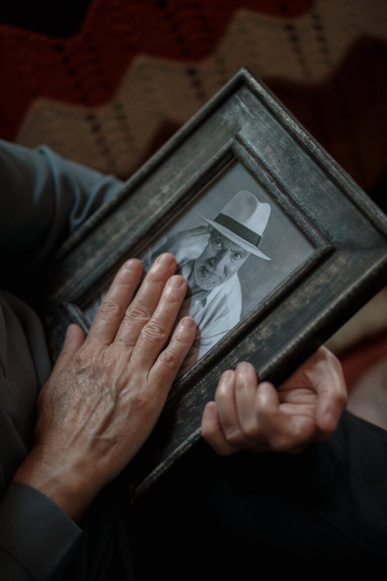 Close-up of a senior man's hands holding a nostalgic photo.