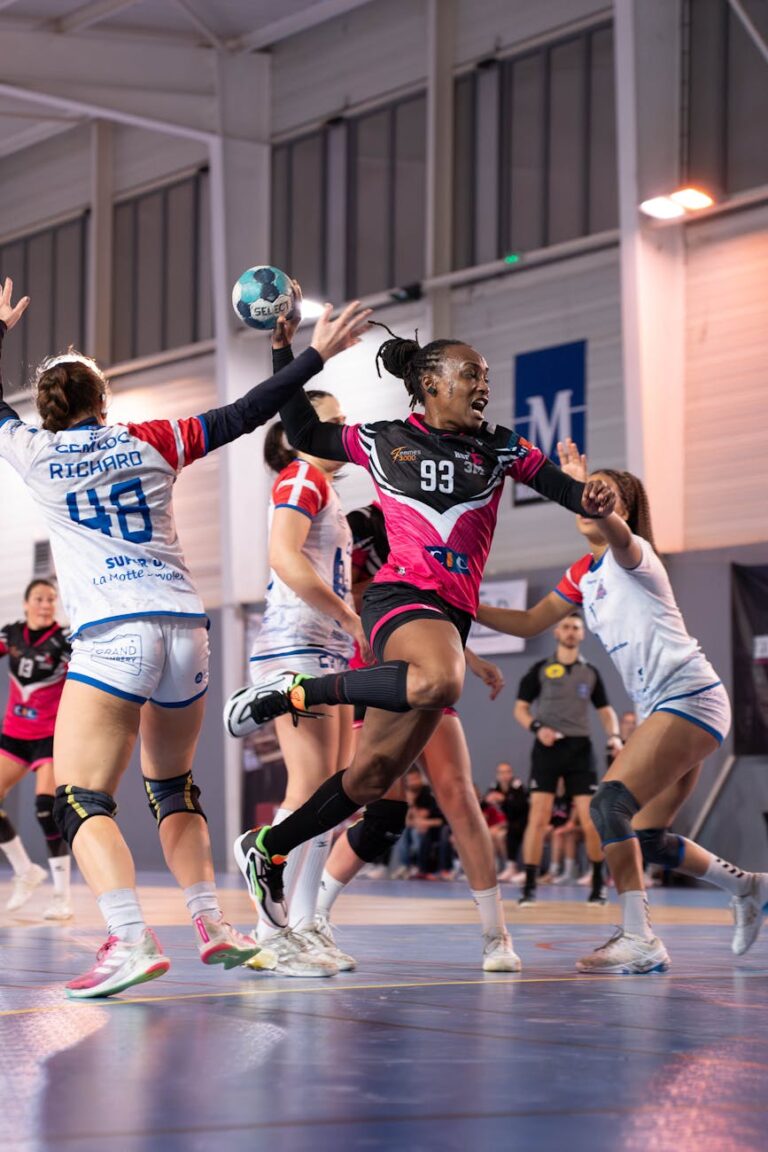 A thrilling moment in a women's indoor handball match capturing the excitement of the game.